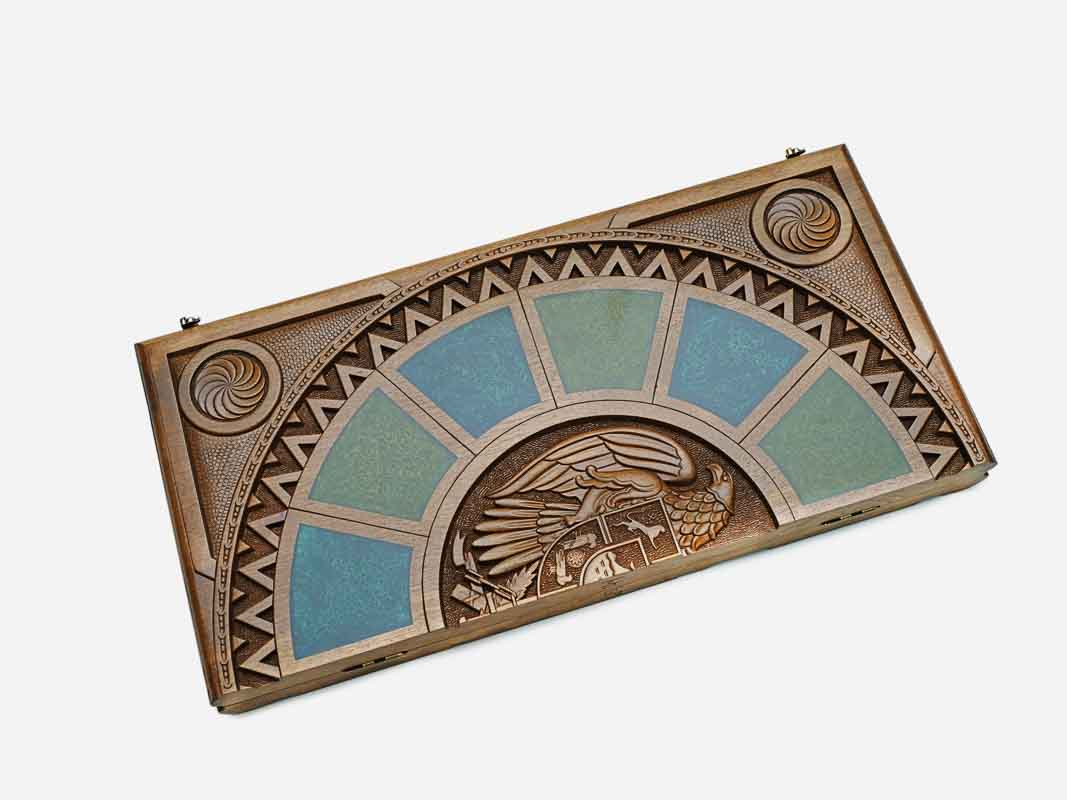 Angled view of the epoxy backgammon board with its carved emblem and zigzag border