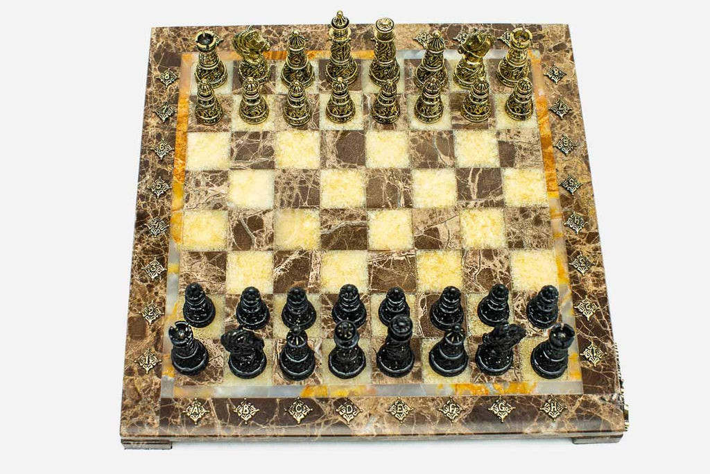 Marble and onyx chess set with brown marble and golden onyx squares and hand-cast bronze pieces arranged for play