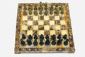 Marble and onyx chess set with brown marble and golden onyx squares and hand-cast bronze pieces arranged for play