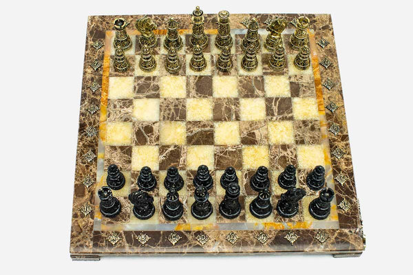 Marble and onyx chess set with brown marble and golden onyx squares and hand-cast bronze pieces arranged for play