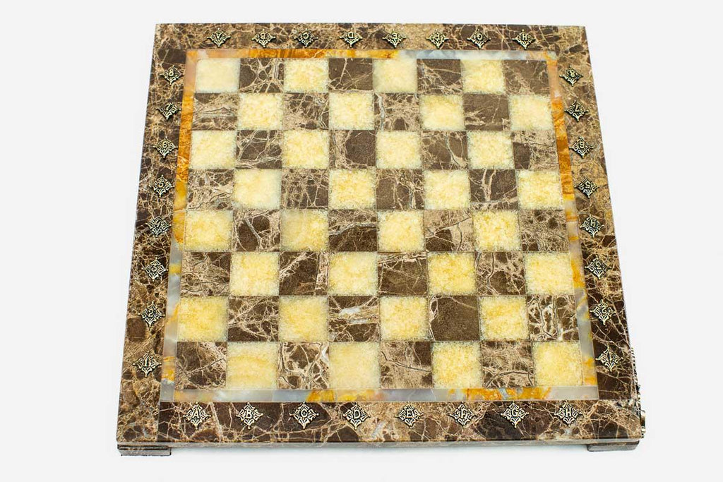 Top-down view of the empty marble and onyx chess board with glowing golden onyx squares and brass markers