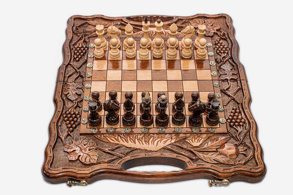 Luxury Armenian walnut chess set carved with pomegranates and grape vines, pieces set up for play
