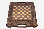 Angled view of the carved walnut board with its bronze chess pieces