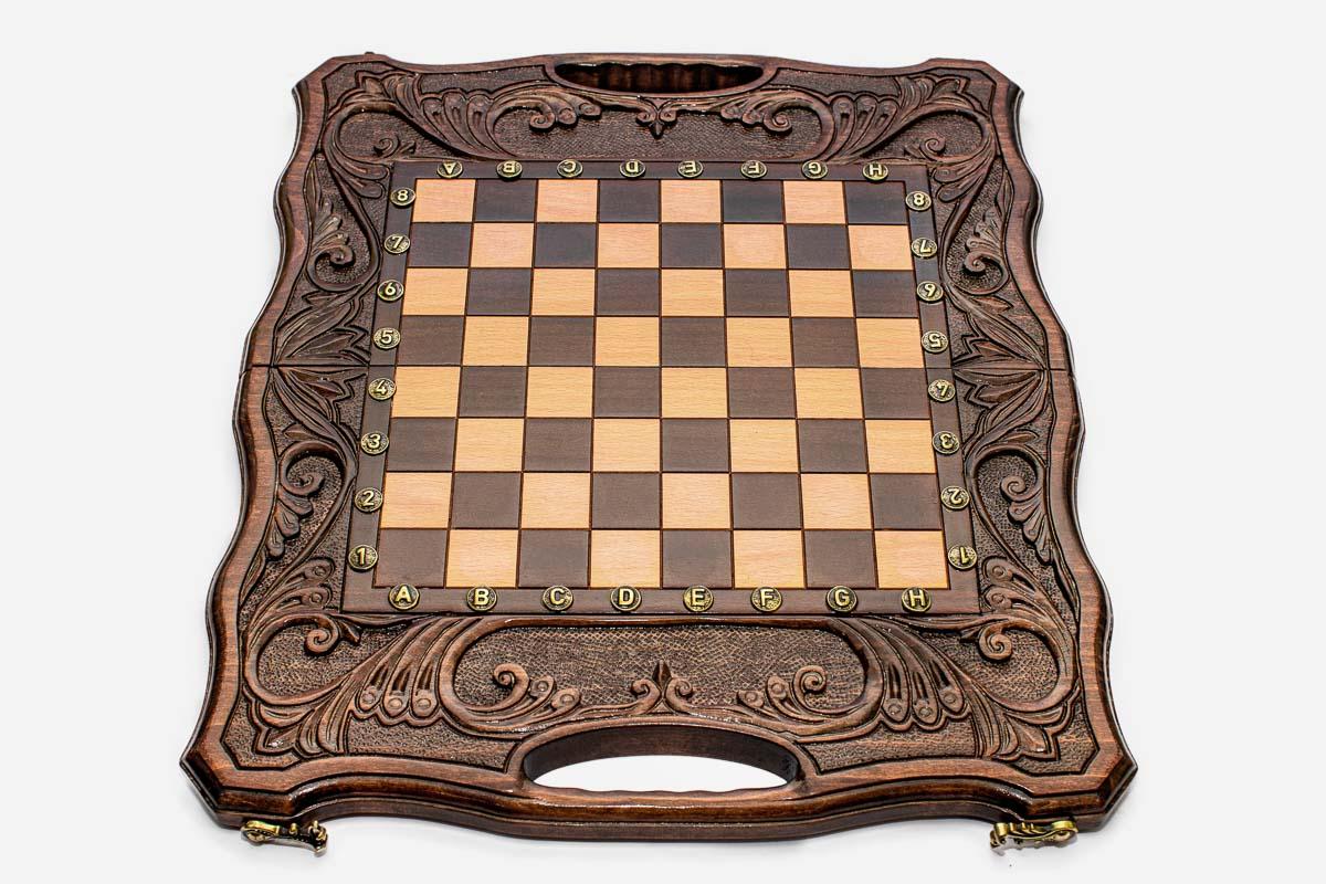 Angled view of the carved walnut board with its bronze chess pieces
