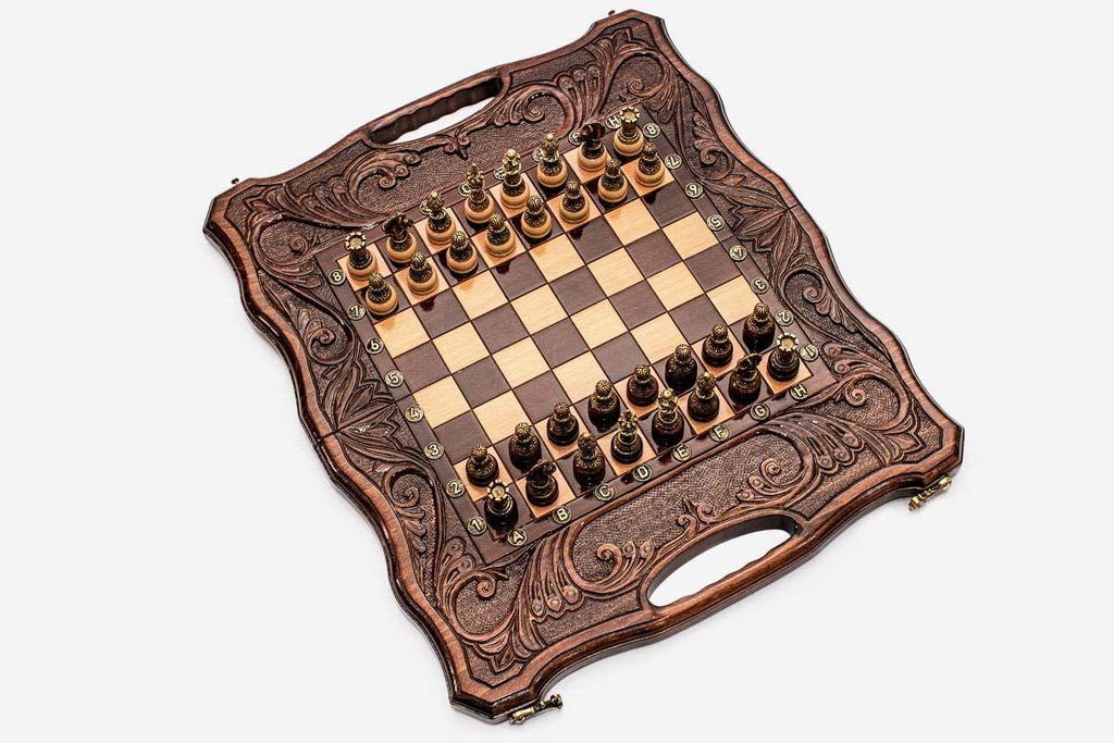 Close-up of the ornate cast bronze chess pieces on cream bases