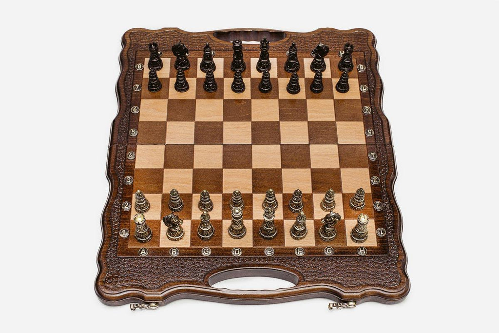 Luxury walnut chess set with carved corners and ornate bronze pieces, the gilded and darkened armies in starting position