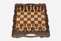 Luxury walnut chess set with carved corners and ornate bronze pieces, the gilded and darkened armies in starting position