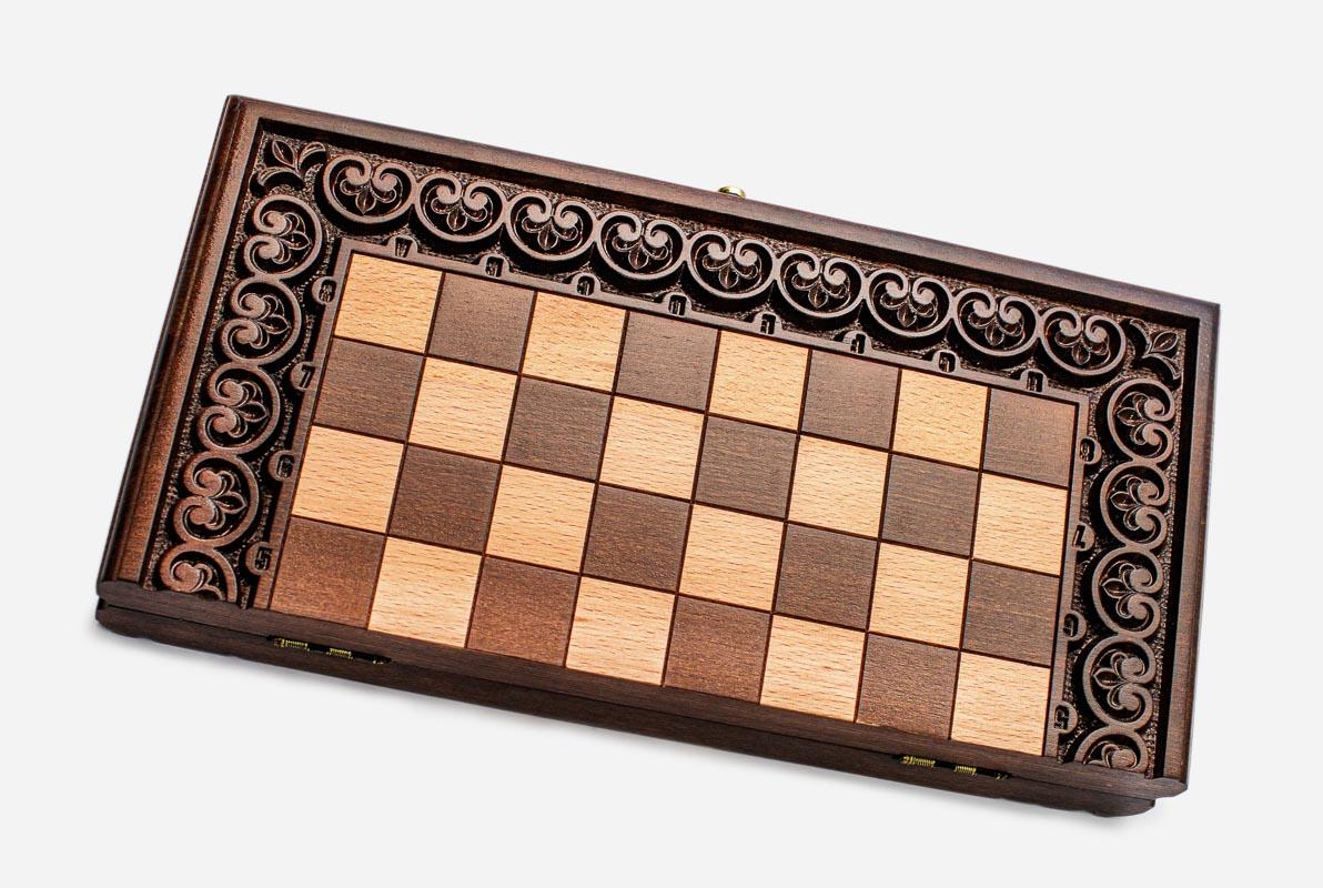 Scrolling floral border hand-carved on a wooden chess board - detail