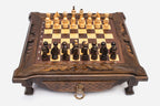 Compact dark walnut chess set shown from the front with pieces set up and a brass drawer ring