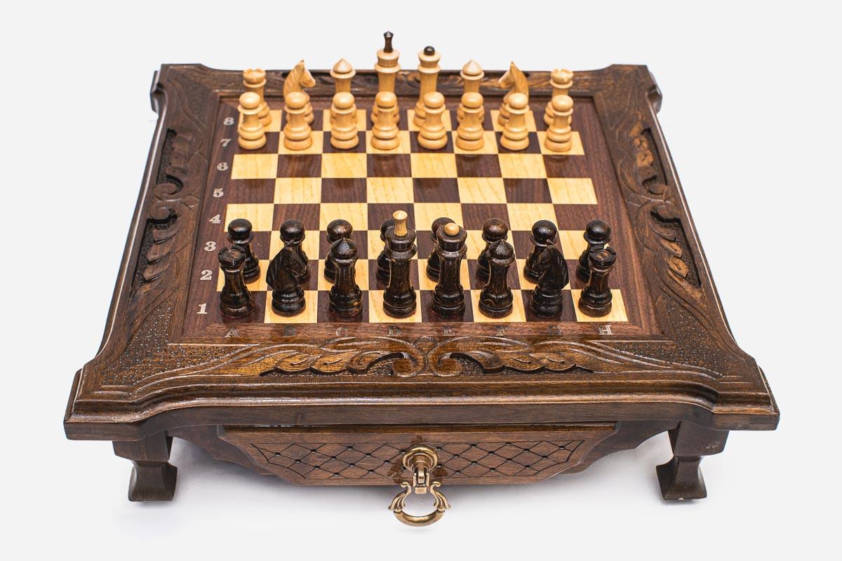 Compact dark walnut chess set shown from the front with pieces set up and a brass drawer ring