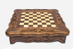 Front view of the compact chess set showing the scalloped carved frame and floral apron