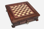 Empty compact wooden chess board with all-over diamond-lattice carving and brass ring handle