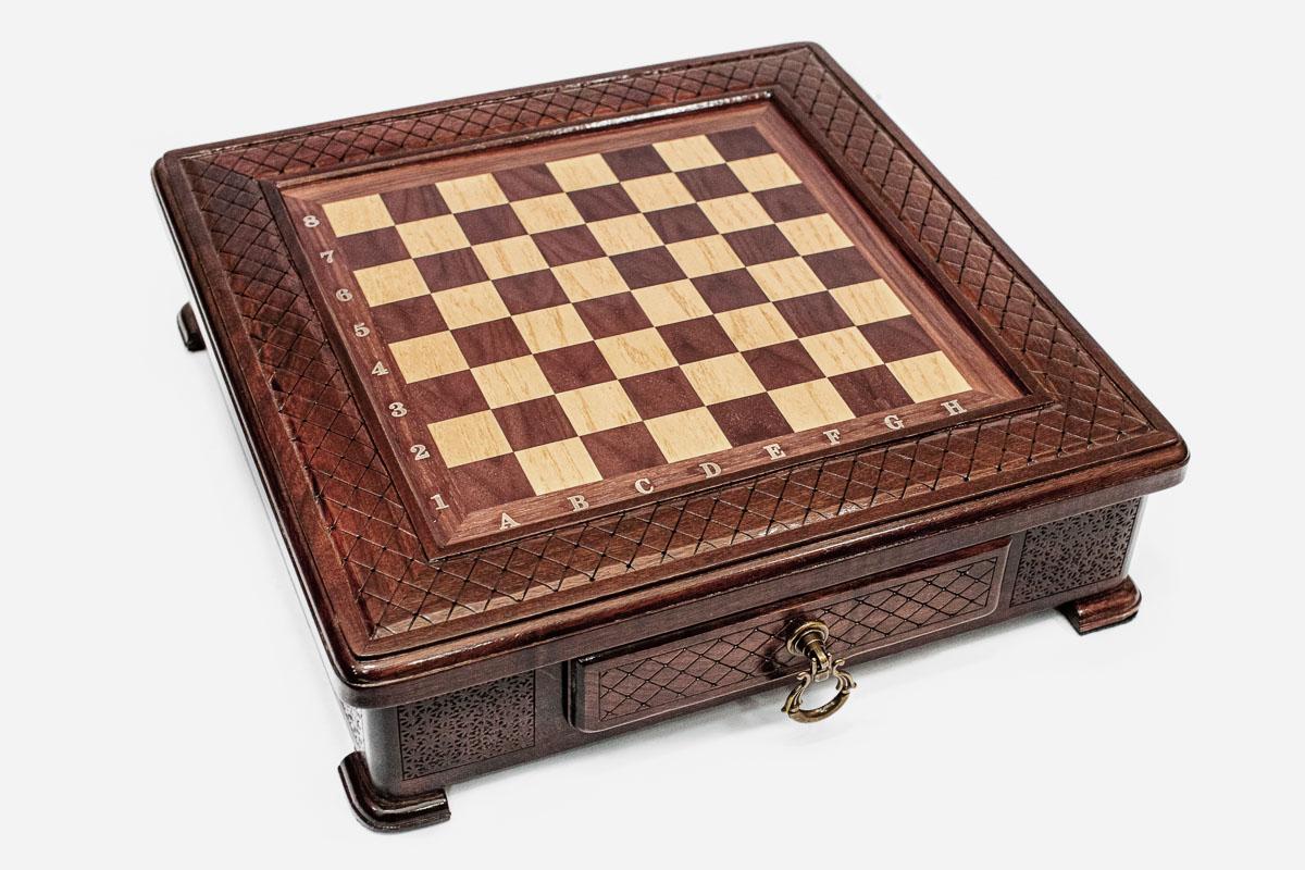Empty compact wooden chess board with all-over diamond-lattice carving and brass ring handle