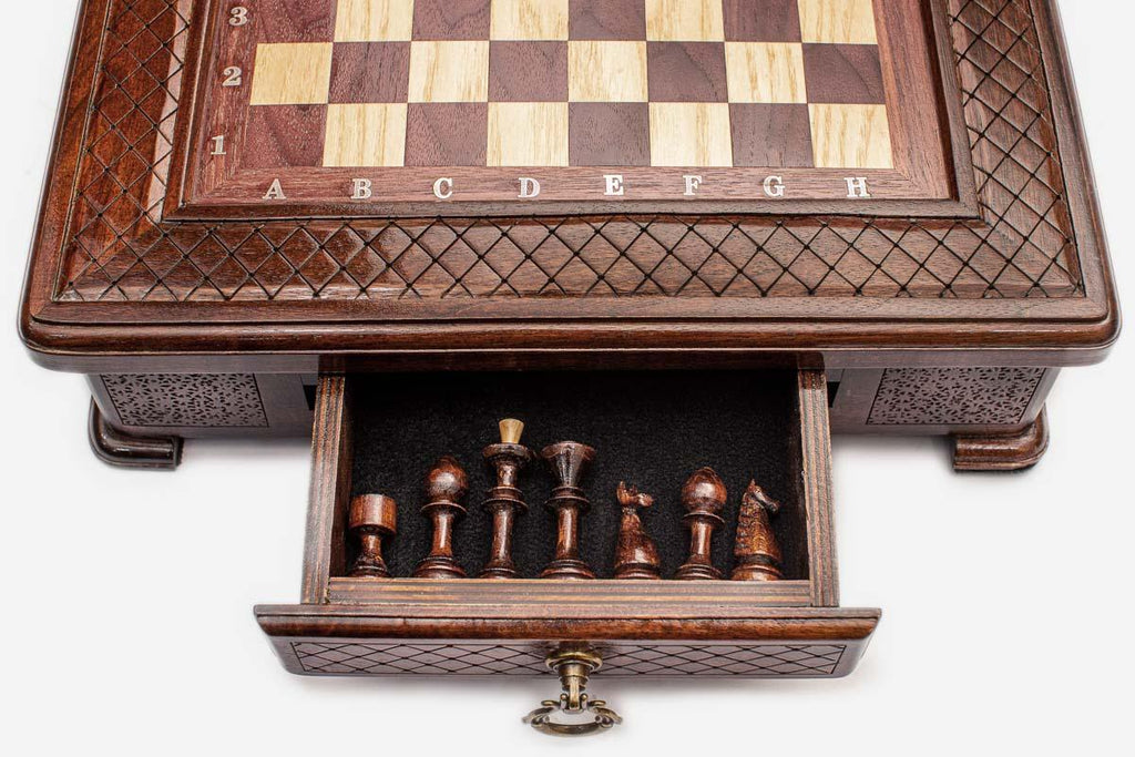 Close-up of the compact chess set's open drawer holding the carved wooden pieces