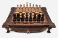 Dark walnut wooden chess set with scroll-carved corners and wooden pieces set up on the inlaid board