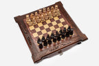 Top angle of the dark walnut chess board with carved scroll corners and pieces arranged for play