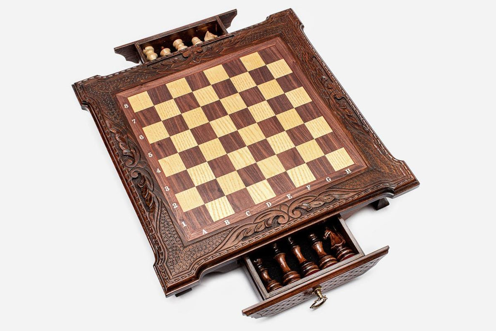 Dark walnut chess set with two storage drawers open revealing the light and dark wooden pieces