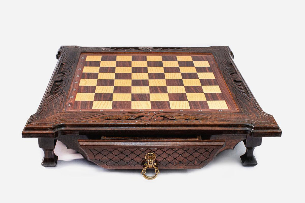 Front view of the dark walnut chess set with scroll-carved corners, shaped feet and brass drawer ring
