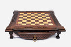 Front view of the dark walnut chess set with scroll-carved corners, shaped feet and brass drawer ring