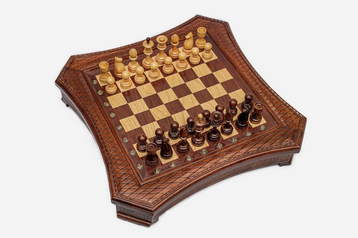 Angled top view of the curved-side chess board with light and dark pieces arranged for play