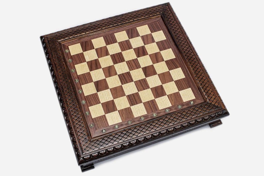 Empty dark walnut chess board showing the carved diamond-lattice and beaded border