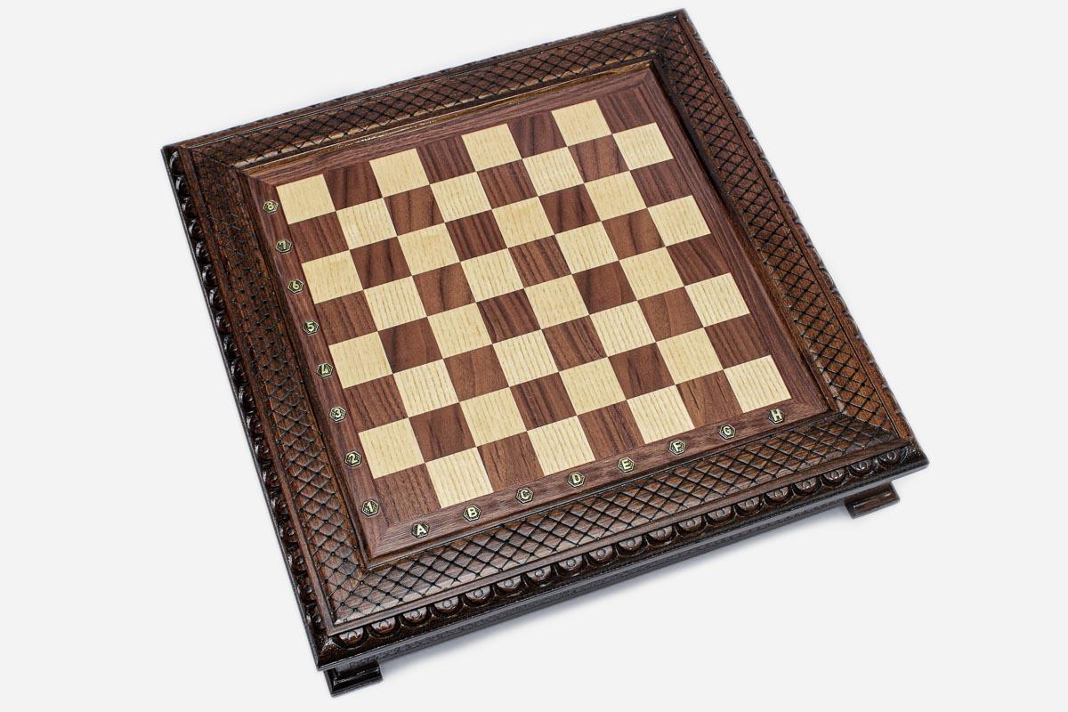 Empty dark walnut chess board showing the carved diamond-lattice and beaded border