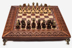 Luxury wood and brass chess set with figural gold-mounted pieces and an openwork filigree carved border, shown from the front