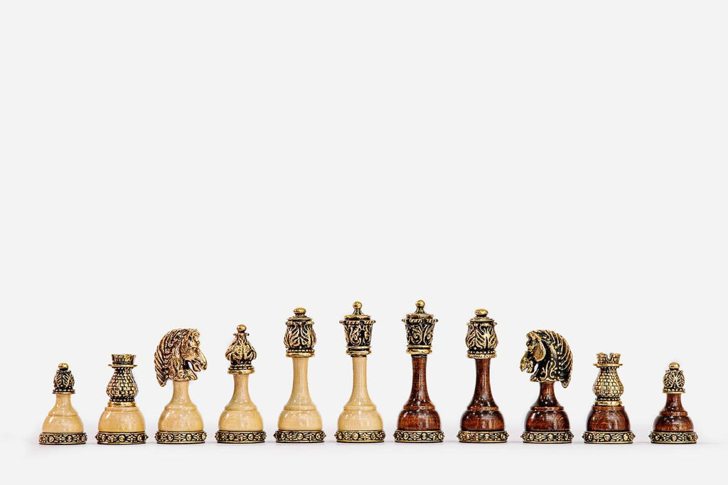 Row of the wood and brass chess pieces showing carved lion-head knights and filigree brass bases