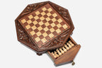 Octagonal chess set with the storage drawer open showing the light wooden pieces inside