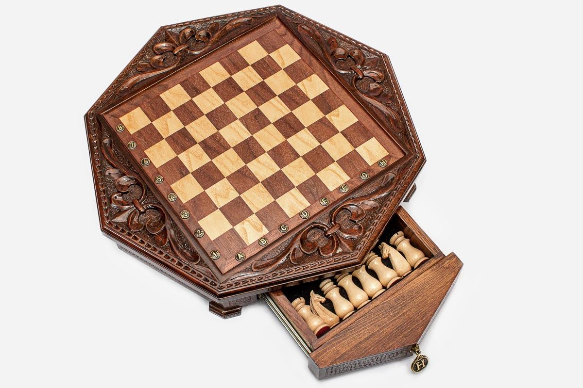 Octagonal chess set with the storage drawer open showing the light wooden pieces inside