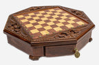 Angled view of the empty octagonal chess board with carved fleur-de-lis border and brass drawer pull