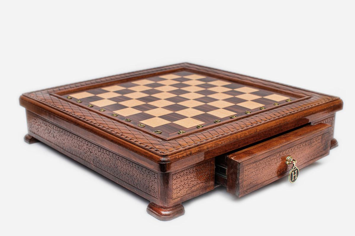 Side view of the square carved chess set with its pull-out storage drawer