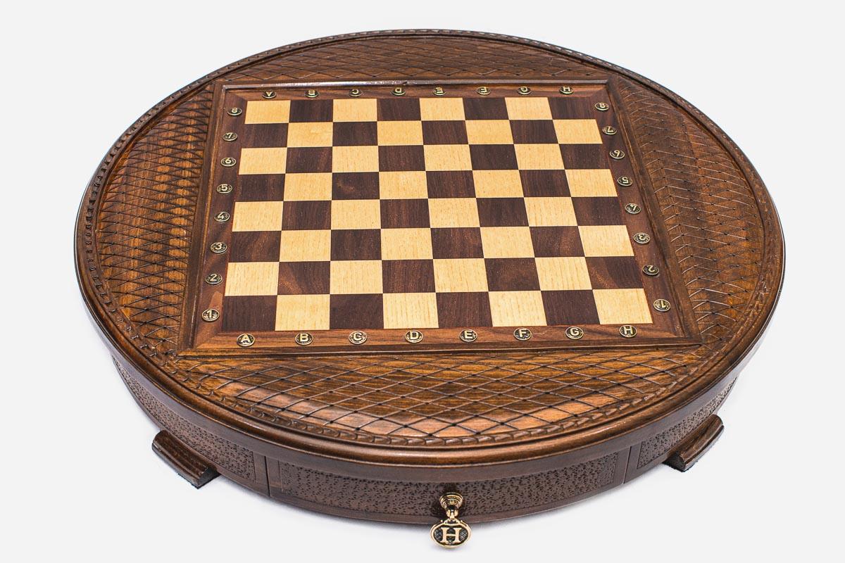 Angled view of the round carved chess set showing the diamond-lattice border and inlaid checkered board