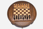 Round wooden chess set with woven lattice-carved border and wooden pieces set up on the inlaid board