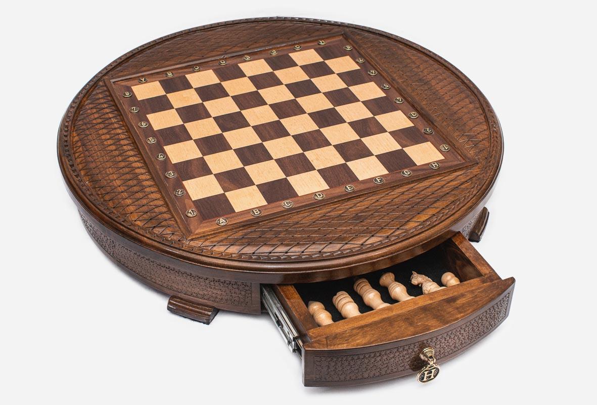 Round chess set with the storage drawer pulled out revealing the chess pieces inside