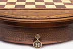 Detail of the round chess set's carved base and brass drawer pull