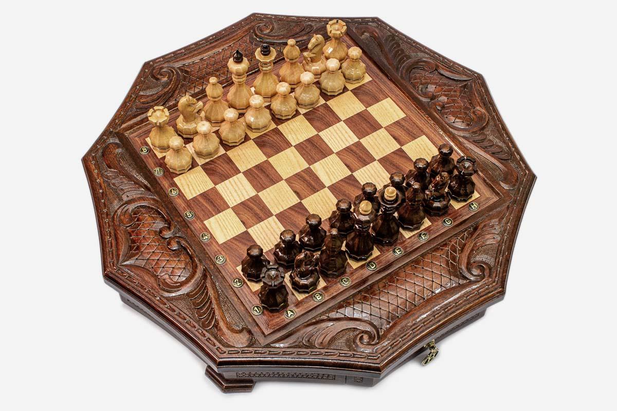 Top-down view of the mahogany octagonal chess board with pieces set up and carved corner scrollwork