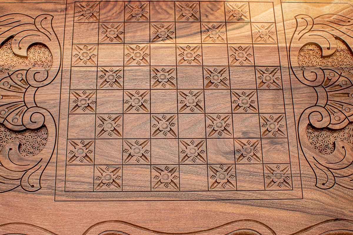 Carved floral square pattern detail on the walnut backgammon board