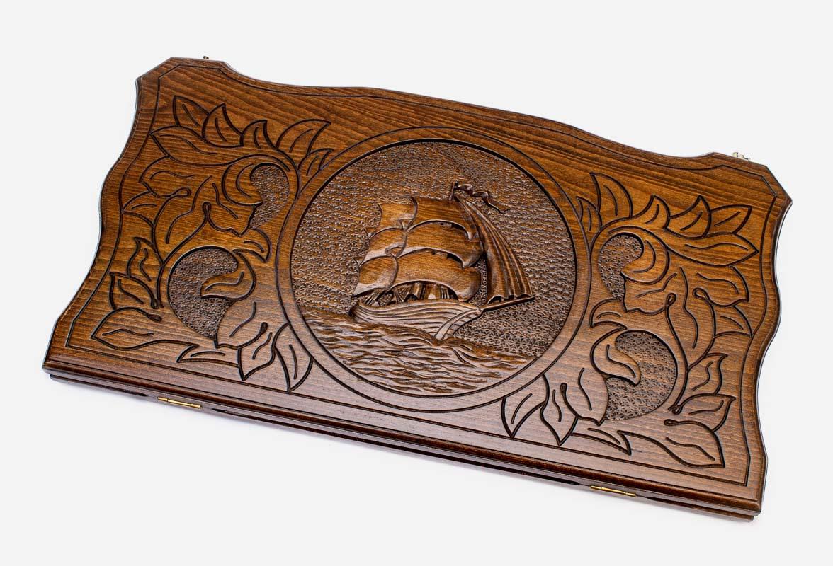 Hand-carved tall ship under full sail on wooden backgammon set