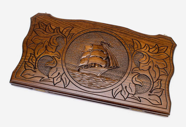 Hand-carved tall ship under full sail on wooden backgammon set