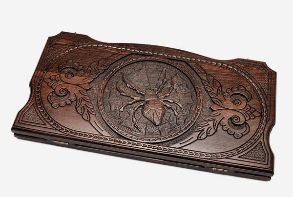 Hand-carved spider and web on wooden backgammon set lid