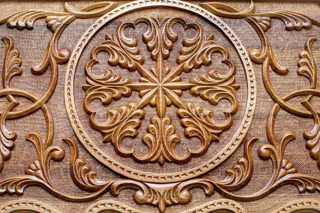 Close-up of the deep-carved ornament in dark walnut