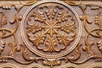 Close-up of the deep-carved ornament in dark walnut