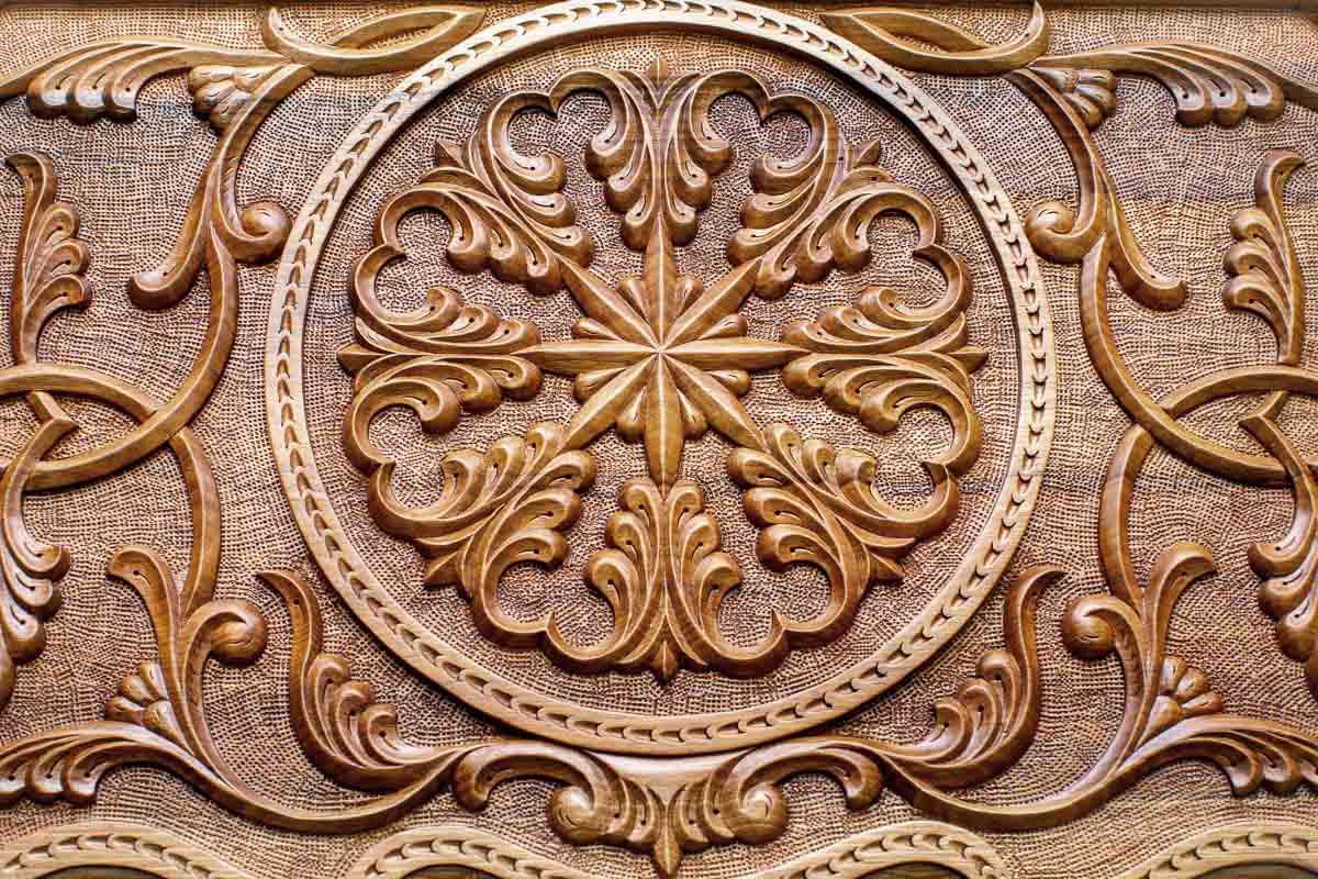Close-up of the deep-carved ornament in dark walnut