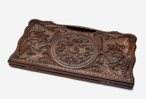 Carved beechwood backgammon board with a central floral ornament, propped open