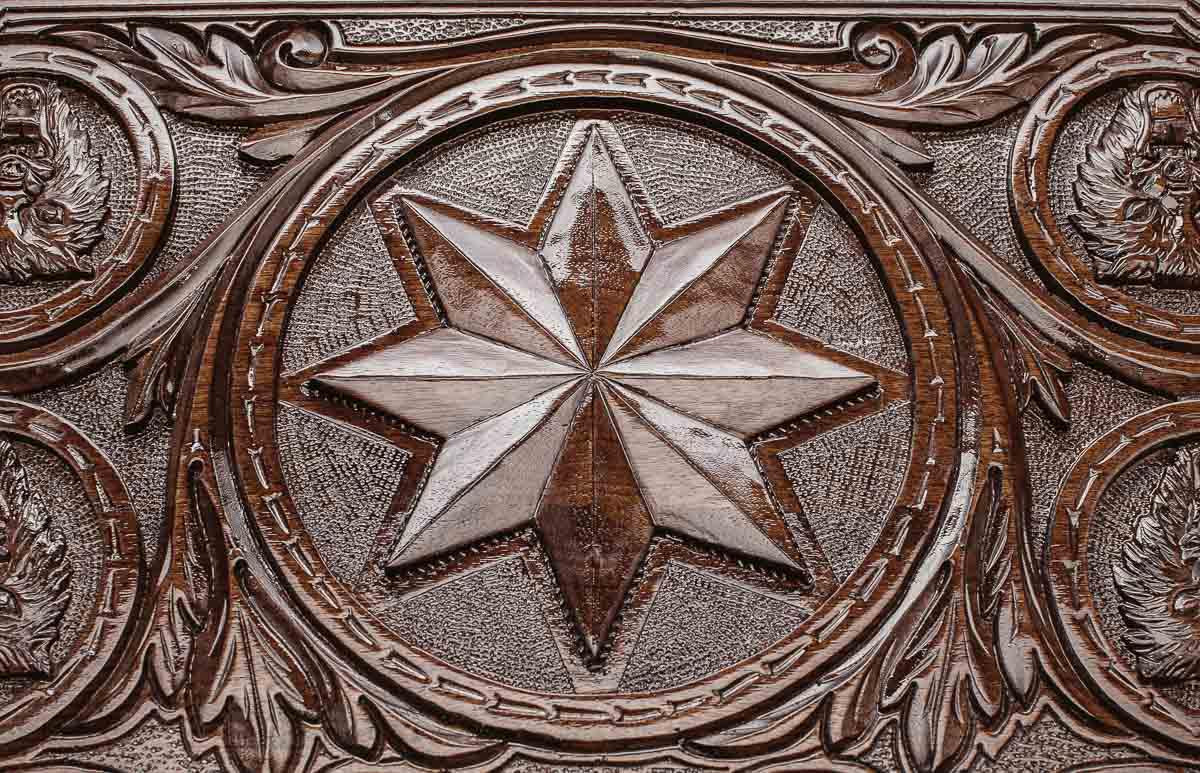 Close-up of the carved wolf in dark walnut
