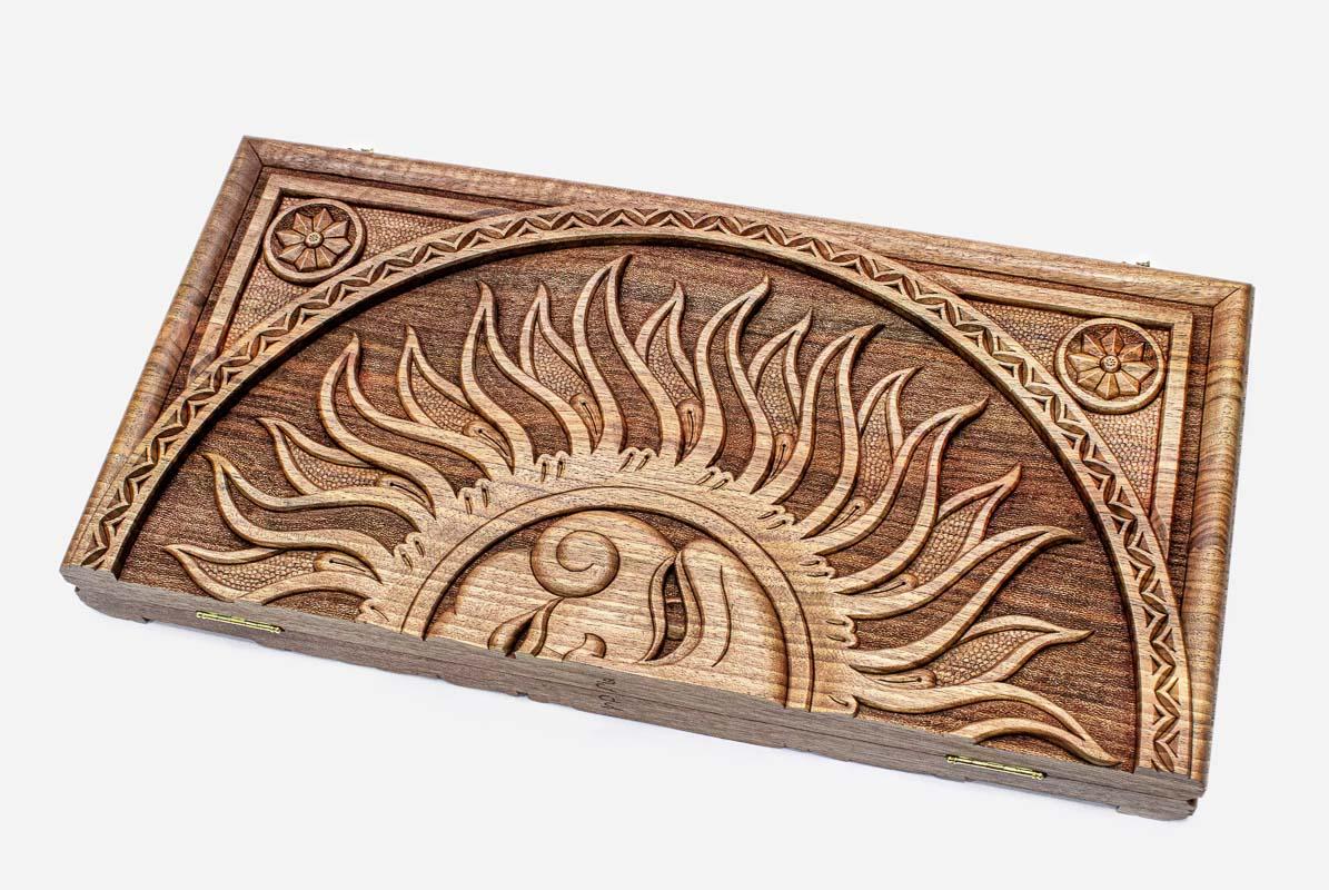 Master-carved walnut backgammon board with a radiant sun, propped open