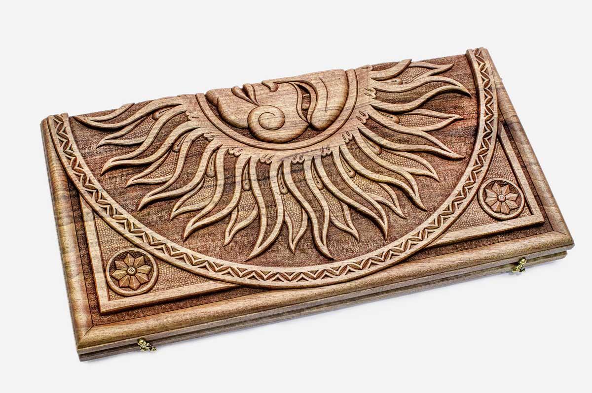 Angled view of the sun master carved walnut backgammon board