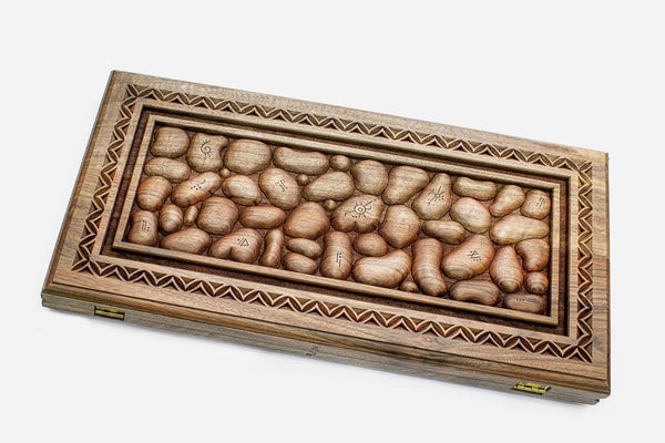 Master-carved walnut backgammon board resembling a bed of river stones, propped open