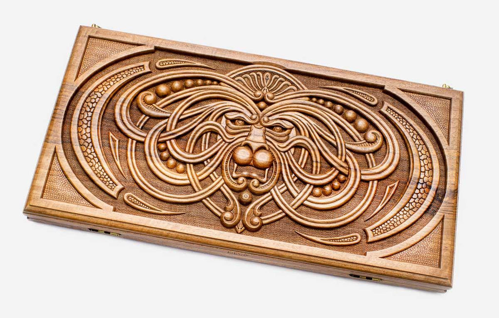 Master-carved walnut backgammon board with a symmetrical carved mask, propped open